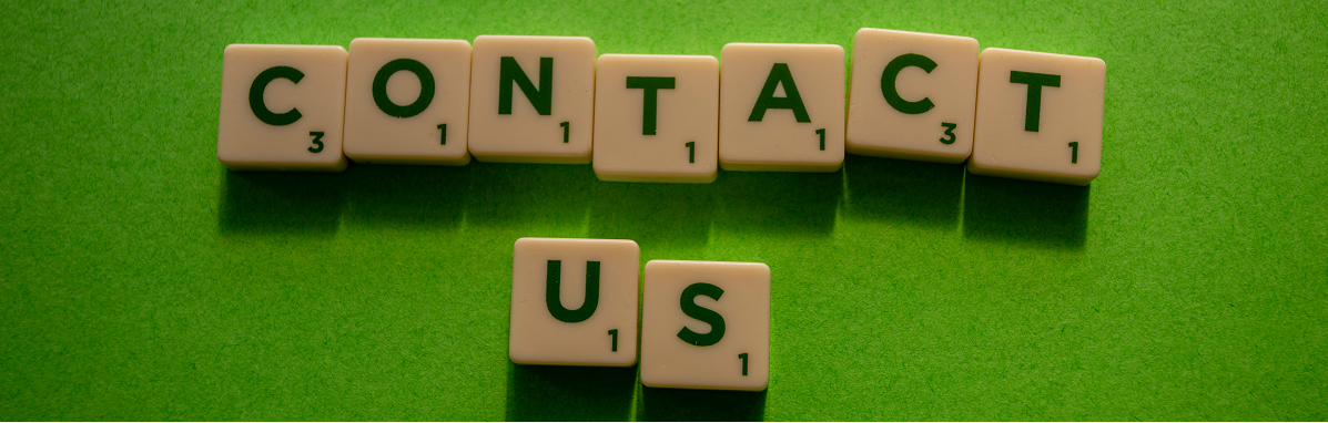 Scrabble letters spelling the words 'contact us' against a bright green background.